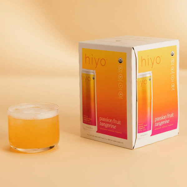 hiyo Passion Fruit Tangerine alcohol-free social tonic four-pack box with poured glass