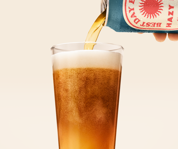 Best Day Hazy IPA non-alcoholic beer poured from can into a pint glass with a foamy head