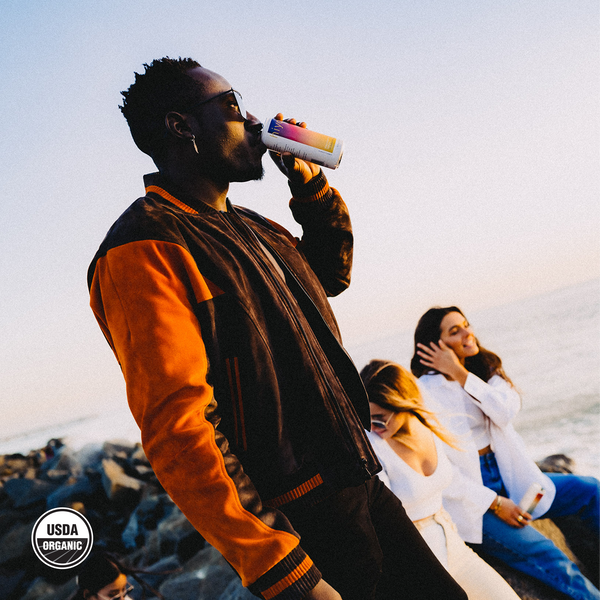 hiyo Blackberry Lemon alcohol-free functional seltzer can sipped by a man on a rocky beach