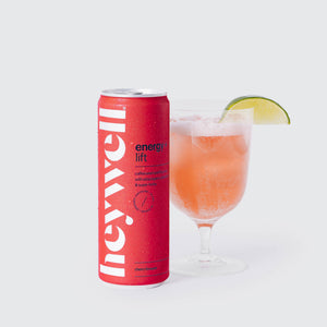 Heywell energy + lift cherry limeade alcohol-free functional beverage can beside a glass with lime wedge