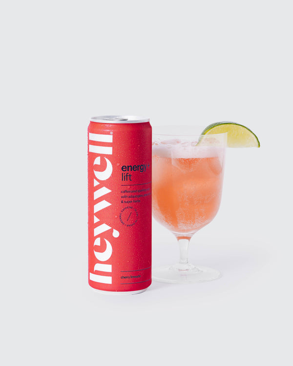 Heywell energy + lift cherry limeade alcohol-free functional beverage can beside a glass with lime wedge