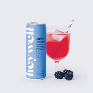 Heywell Calm + Restore Blackberry Ginger alcohol-free sparkling water can with poured glass and blackberries