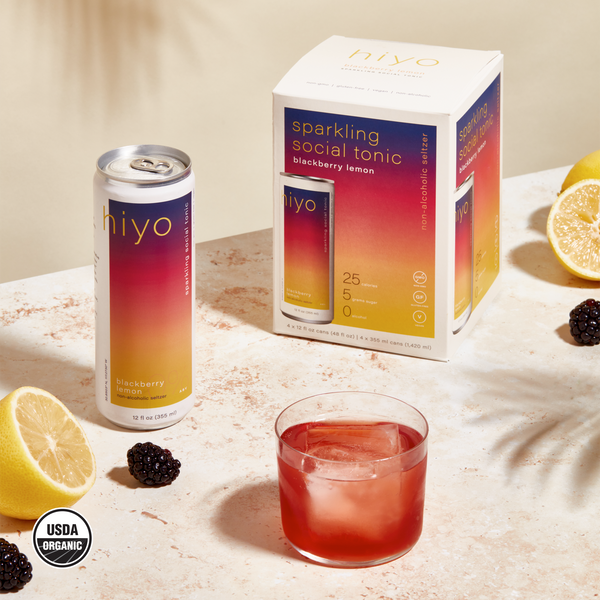 hiyo Blackberry Lemon alcohol-free functional seltzer can and four-pack box with glass, lemons, and blackberries
